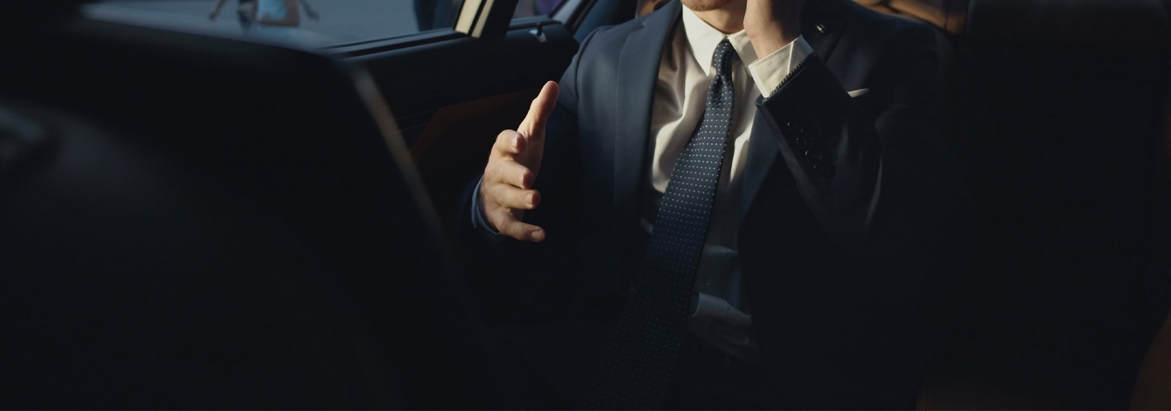 Smiling businessman talking on mobile phone in interior of business car. Carleone luxury car rental Bangkok Thailand limousine service airport transfer in a sleek sedan.