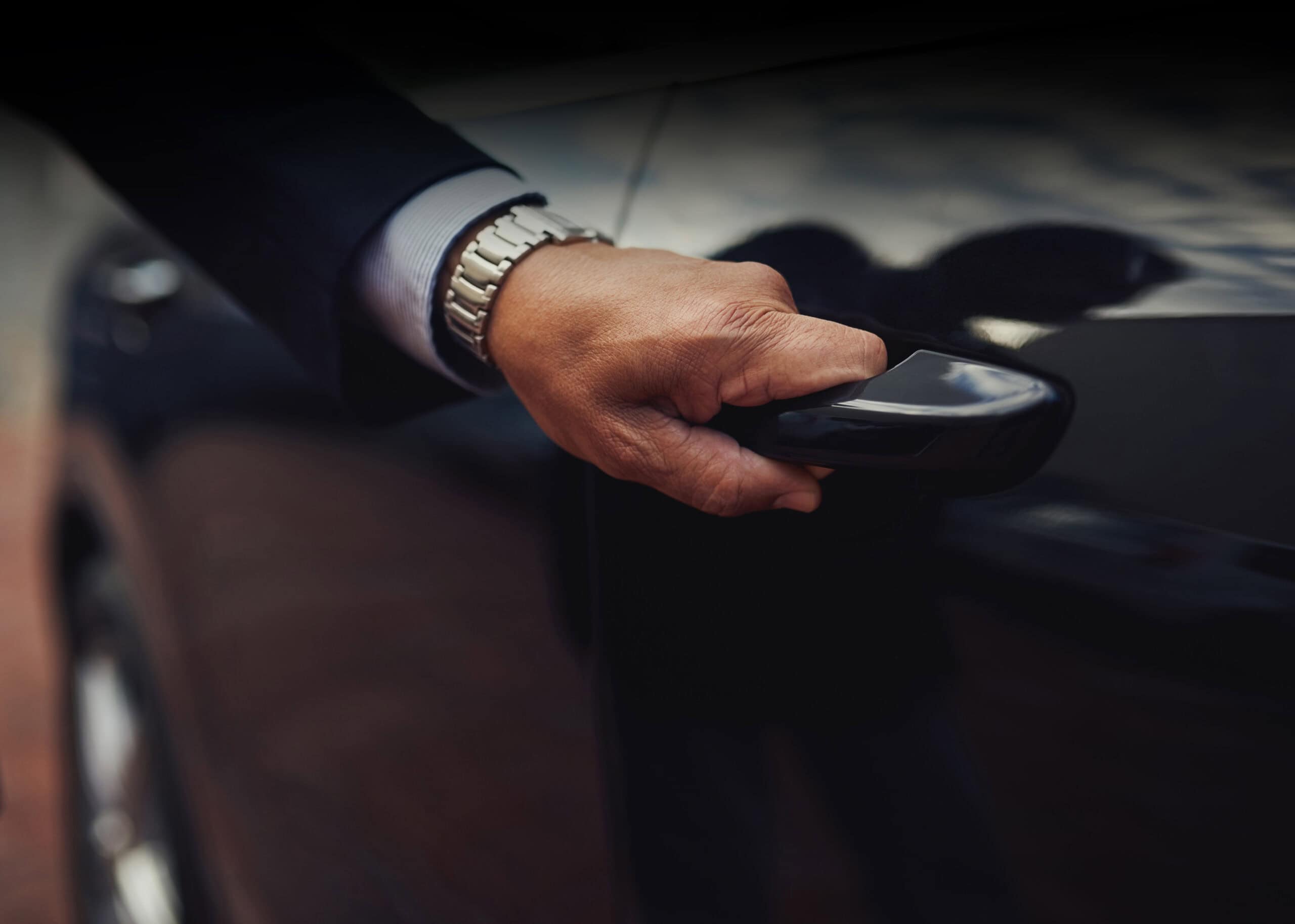 Travel in top class style. Cropped shot of a businessman opening Luxury Car Rental Carleone chauffeur opening car door in Bangkok Thailand for premium limousine airport transfer.